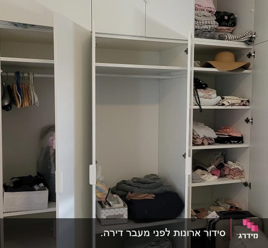 ארון בגדים פתוח עם מדפים מלאים בבגדים מקופלים